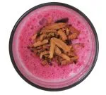 granules on pink liquid in a glass